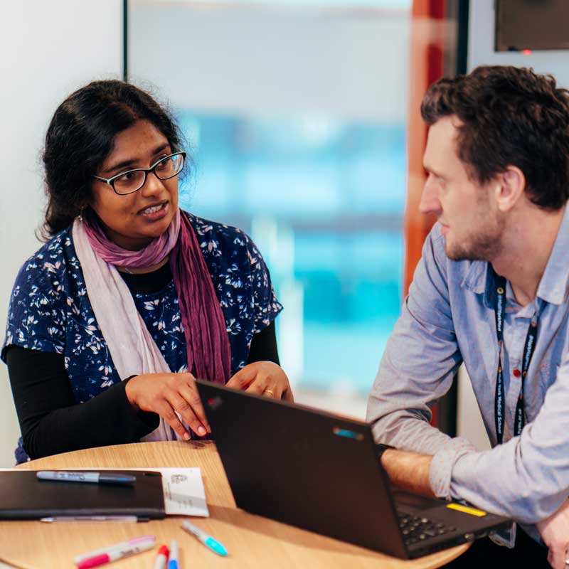 Members of the CATALYST programme in a discussion around a laptop