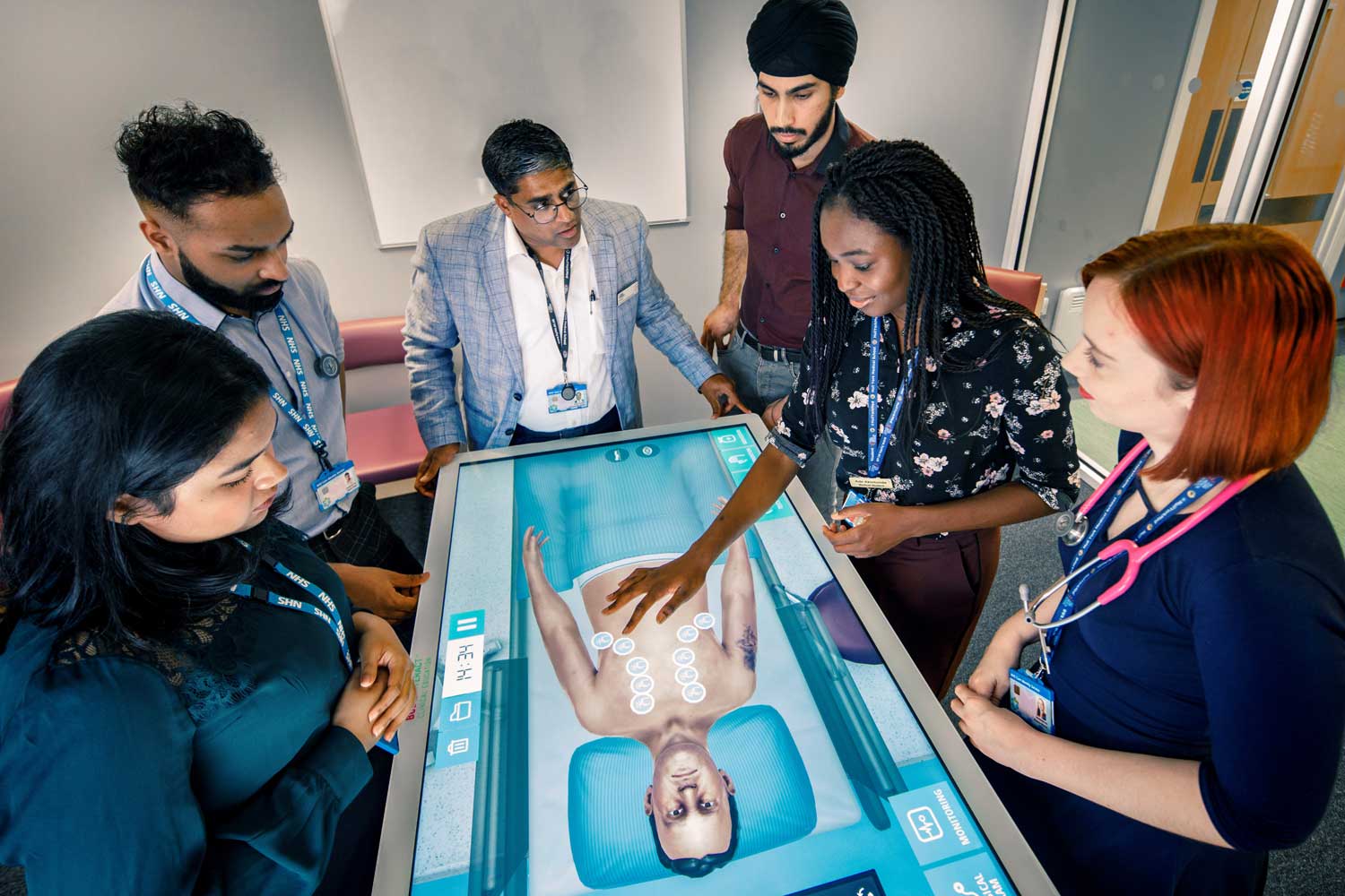 Medical students practicing diagnosing patients with a digital table at Hull Royal Infirmary