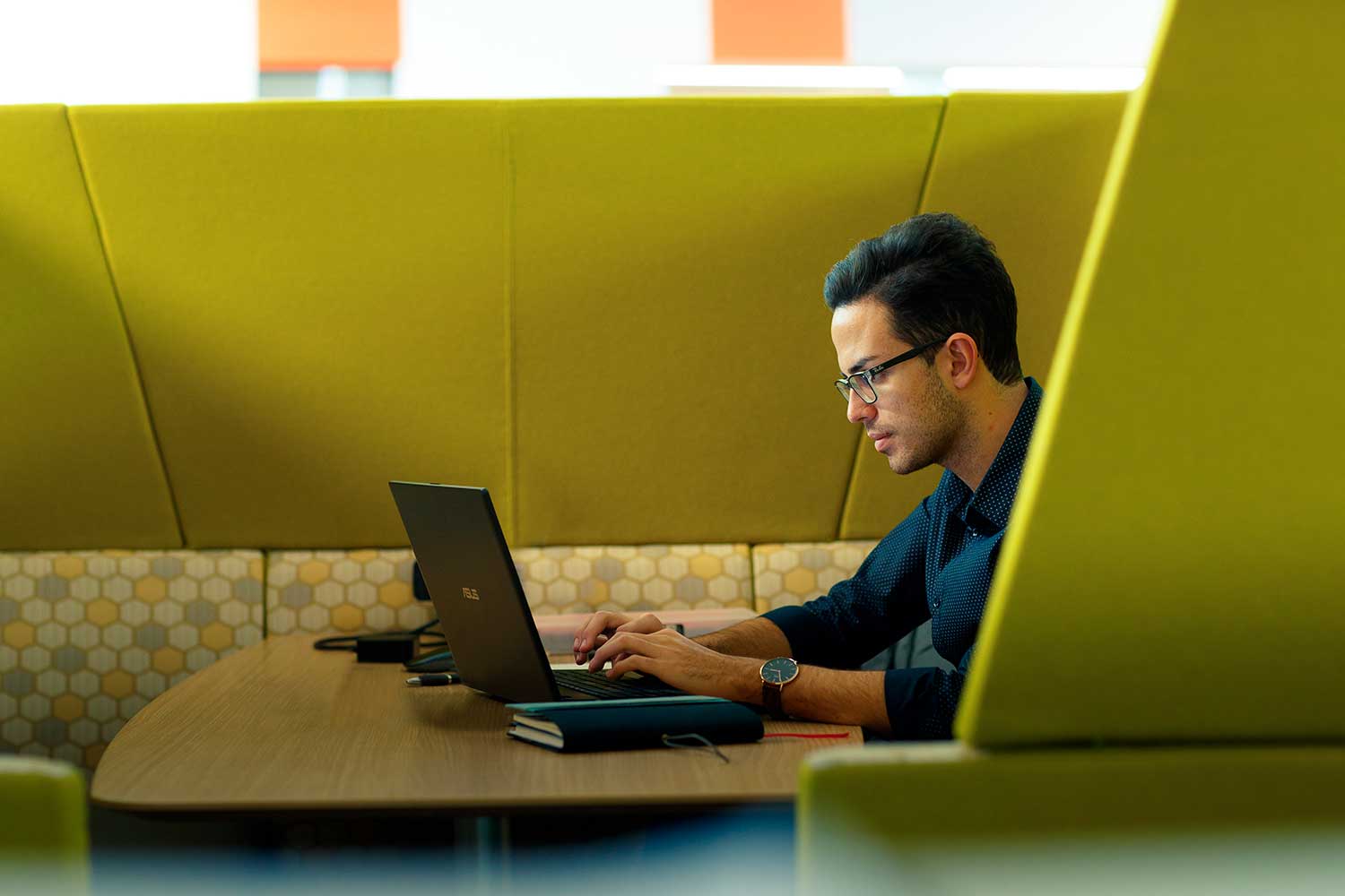 Medicine student Vassili Crispi working on a laptop on the collaboration deck in the Allam Medical Building at the University of Hull