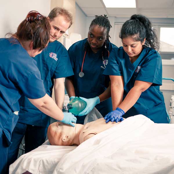 Medical students and an instructor learning CPR on a SIM man