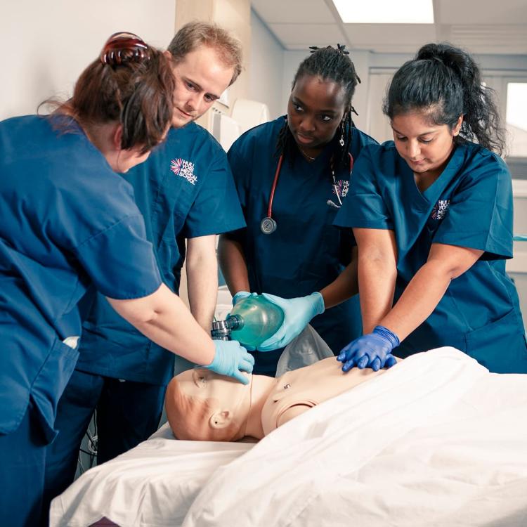 Medical students and an instructor learning CPR on a SIM man