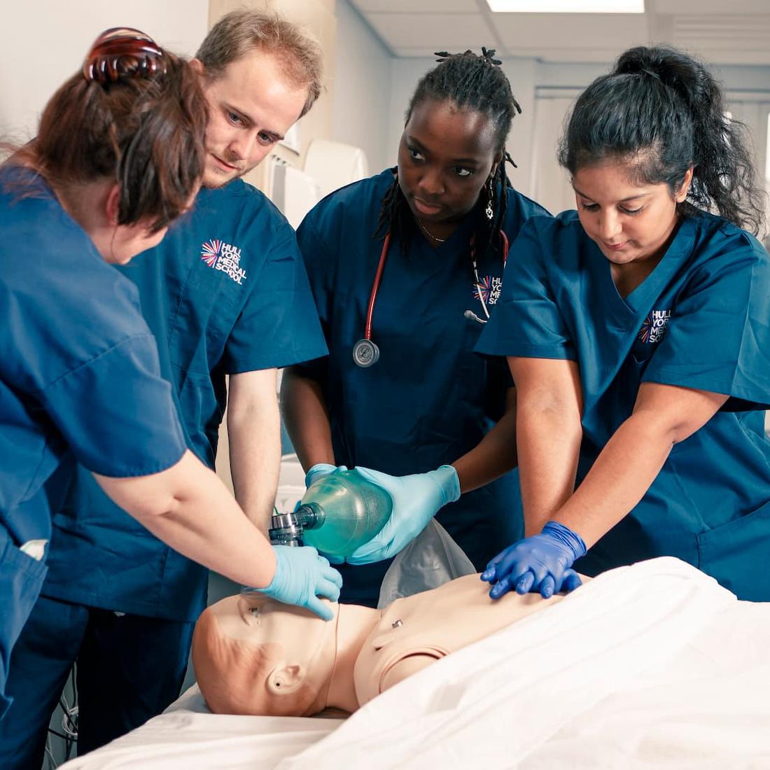 Medical students and an instructor learning CPR on a SIM man