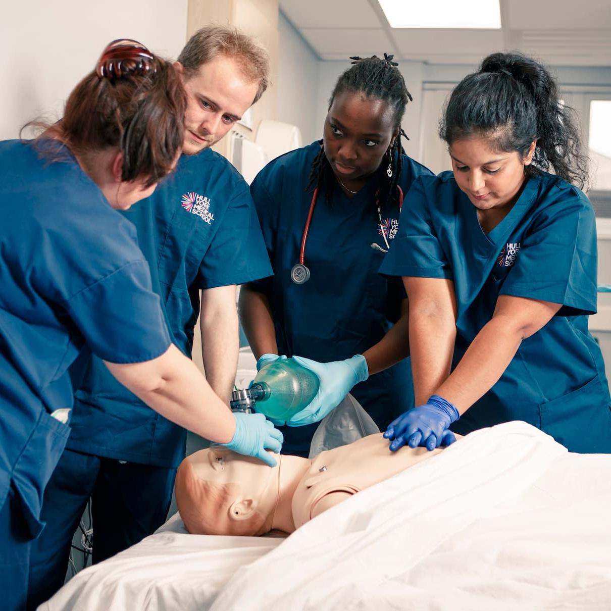 Medical students and an instructor learning CPR on a SIM man