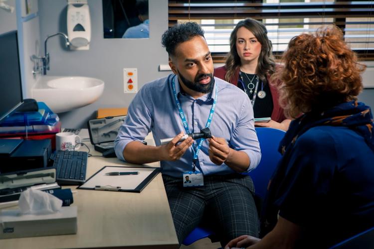 Medical student with patient a GP surgery, being supervised by a GP