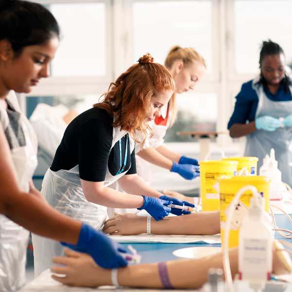 Students practising taking bloods in clinical skills