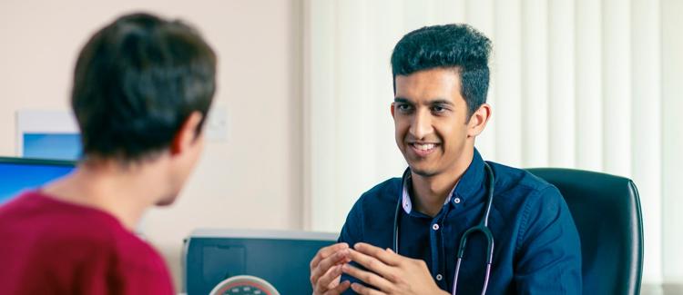 A GP talking to a patient in a consultation room
