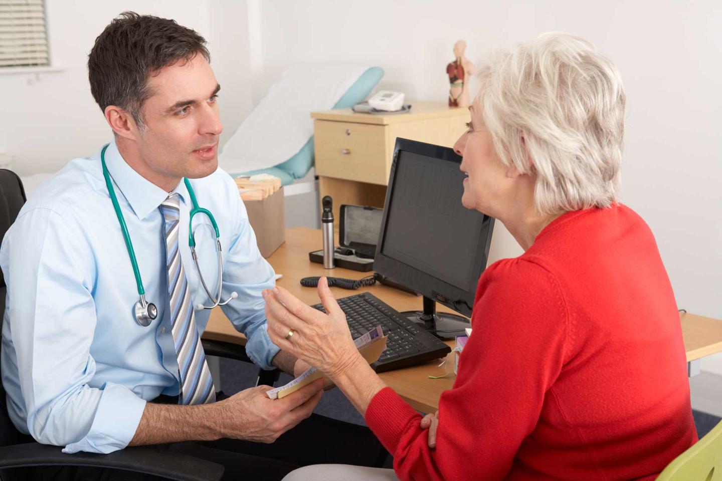 GP talking to a senior woman in the surgery