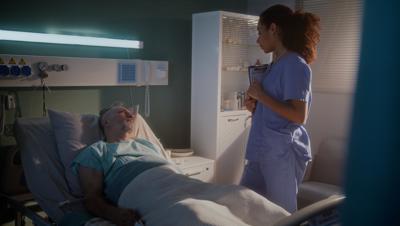 A health professional at the bedside of a patient