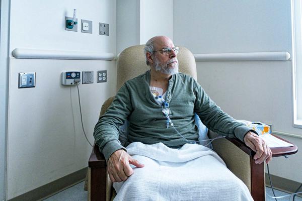 An older adult male having chemotherapy