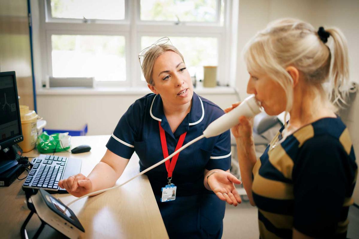 Asthma research nurse with a patient doing a breathing exercise