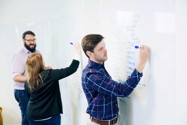 Members of the CATALYST team working on a whiteboard
